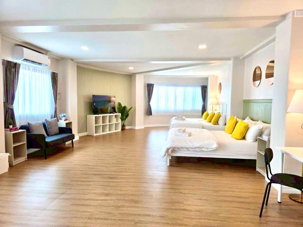 ein großes Wohnzimmer mit einem weißen Bett und gelben Kissen in der Unterkunft The See Stay Hatyai in Hat Yai