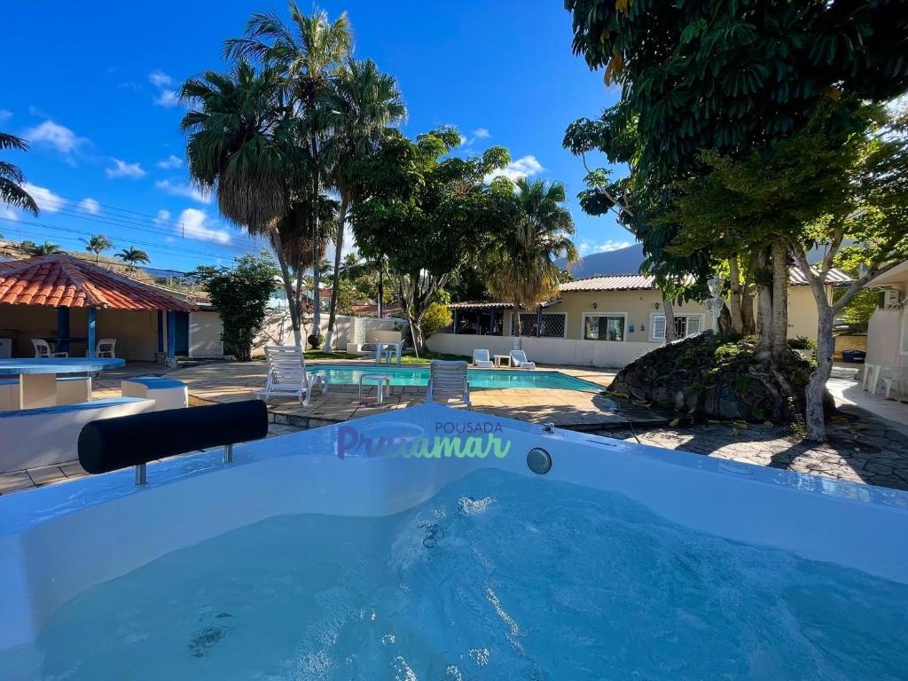 einen großen Pool mit Palmen im Hof in der Unterkunft Pousada Praiamar in São Sebastião