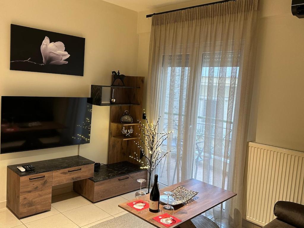 ein Wohnzimmer mit Fernseher und Tisch in der Unterkunft Noufaro in Náousa (Imathia)