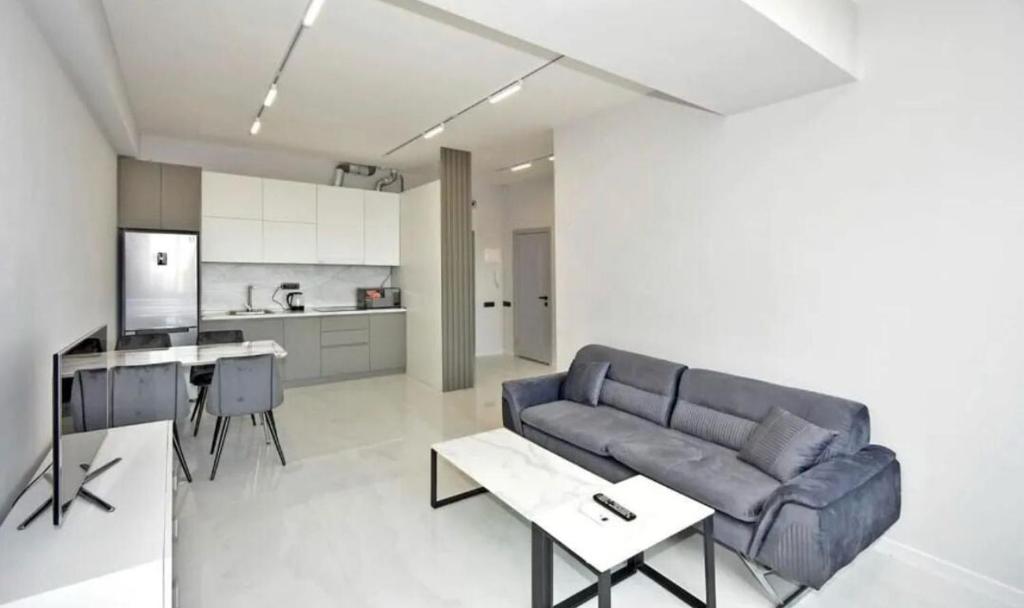 un salon avec un canapé et une cuisine dans l'établissement Comfort Apartment, à Aghk'ilisa