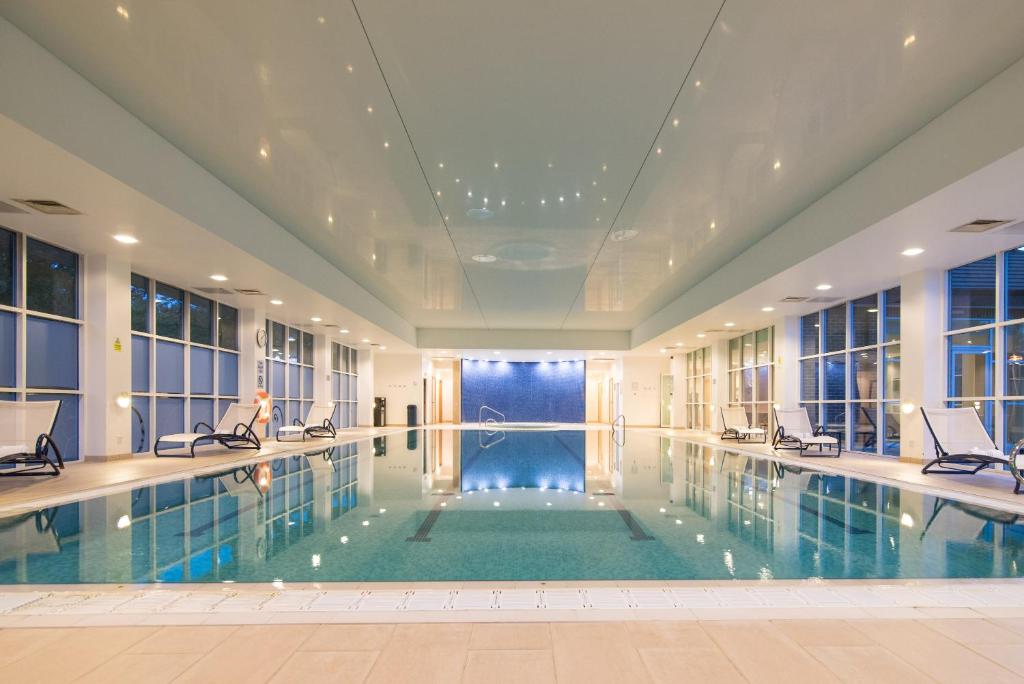a swimming pool in a hotel lobby with a swimming poolvisorvisor at Regency Park Hotel, Health Club & Spa in Newbury