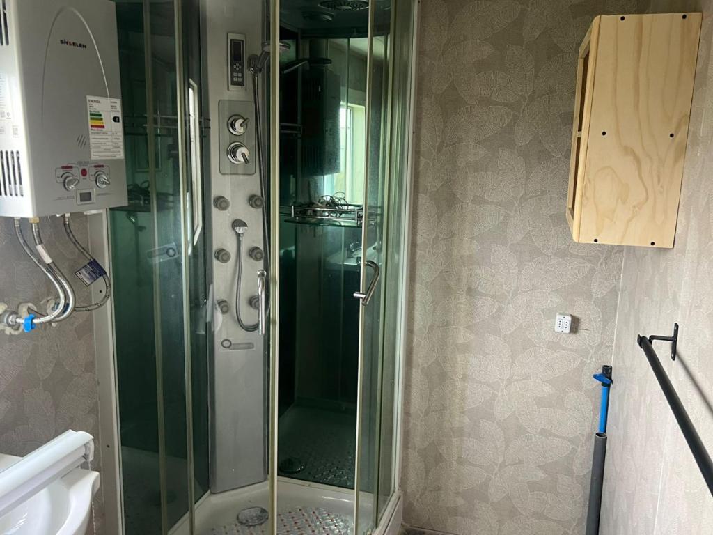 een douche met een glazen deur in een badkamer bij CASA DEL CENTRo 2 in Quellón