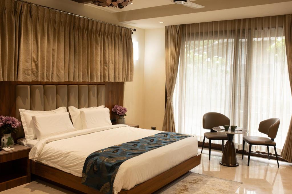 ein Schlafzimmer mit einem Bett, einem Tisch und Stühlen in der Unterkunft Rosse Dale Suites and Hotel Coimbatore in Coimbatore