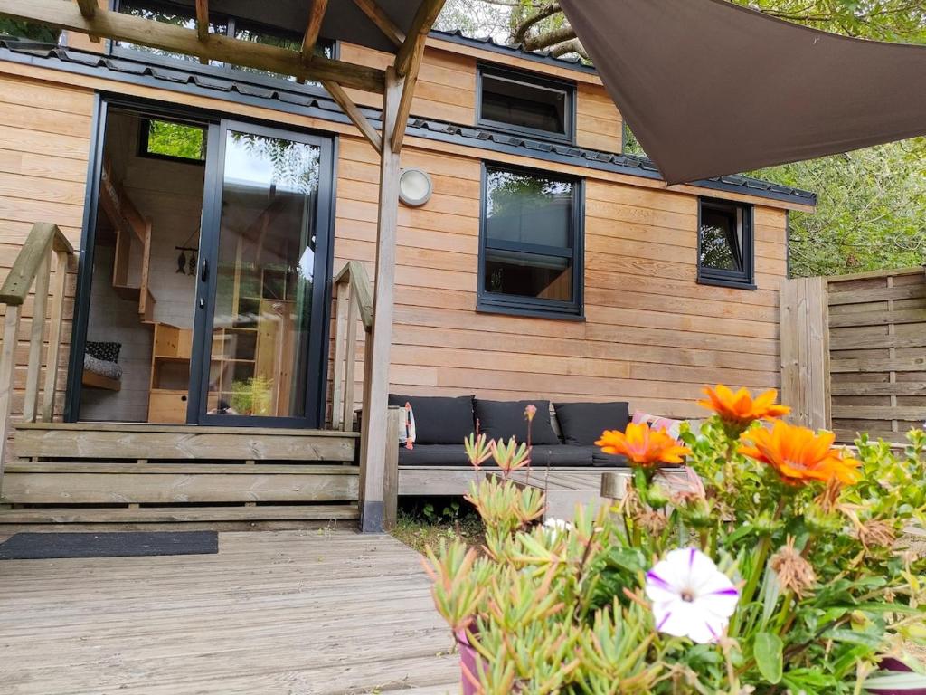 a house with a bench and flowers in front of it at Tiny house Keremma in Tréflez