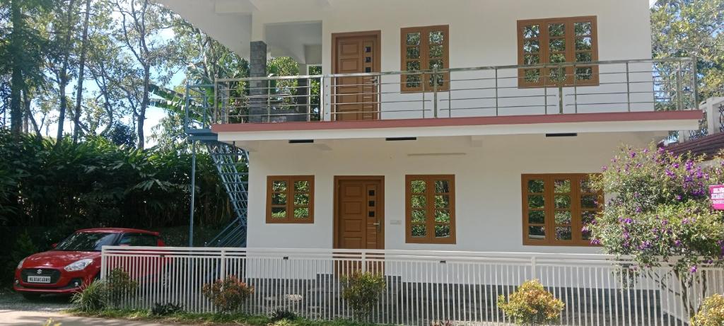 ein rotes Auto, das vor einem Haus parkt in der Unterkunft Silver home stay vagamon in Vagamon