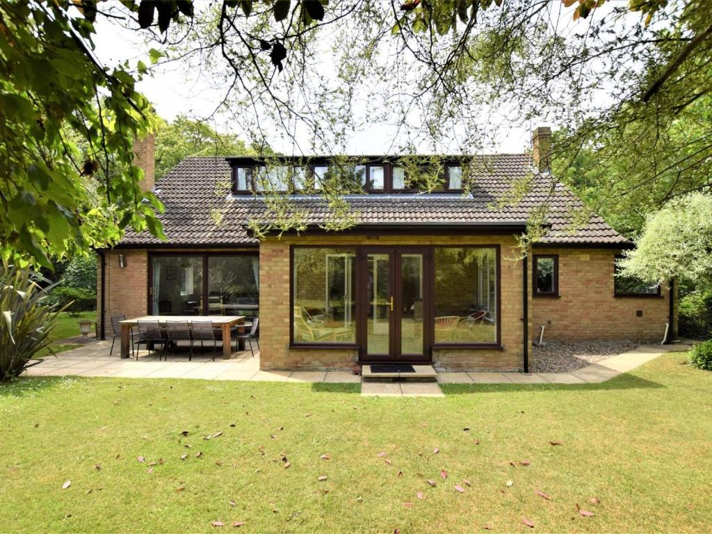 a house with glass doors and a table in a yard at 4 Bed in Cromer oc-kt116 in Cromer