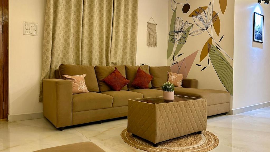 un salon avec un canapé marron et une table dans l'établissement Novo Stays - Artistic Boho Edition, à Hyderabad