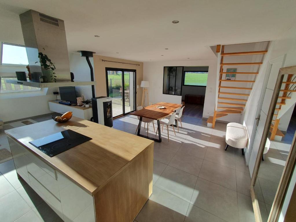 een keuken en woonkamer met een tafel en stoelen bij La maison des Macareux - 5 min des plages in Lamballe Armor