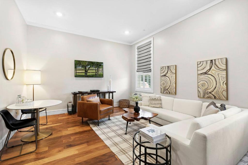 a living room with a white couch and a table at Hotel Suites at Vanderbilt in Westbury