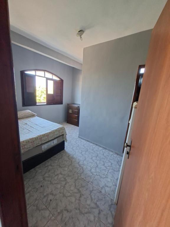 una stanza vuota con un letto e una finestra di Pousada em Ilhéus a Ilhéus