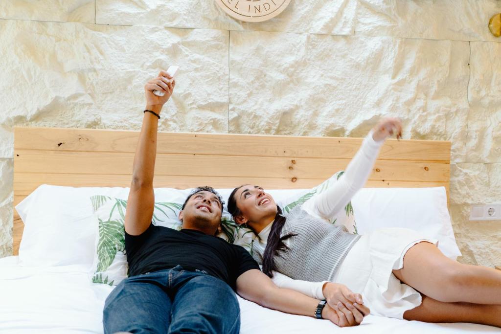 twee mensen liggen op een bed met hun handen in de lucht bij Glamping El Refugio in Archidona