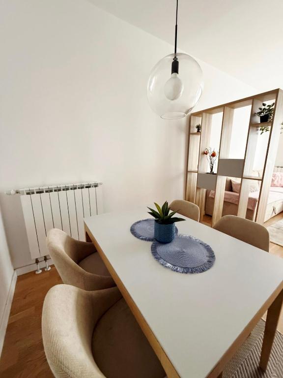 a dining room with a white table and chairs at Bulevar Pent in Sarajevo