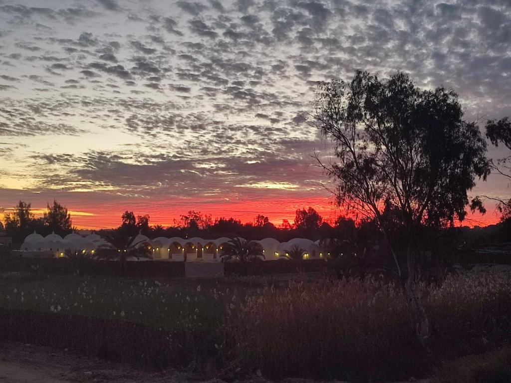 un tramonto in un campo con un cielo dalle nuvole di إيتران - Itran a Siwa