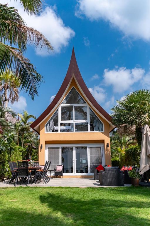 a house with a pitched roof with a patio at Amore Villa by Utalay Koh Chang in Ban Khlong Son