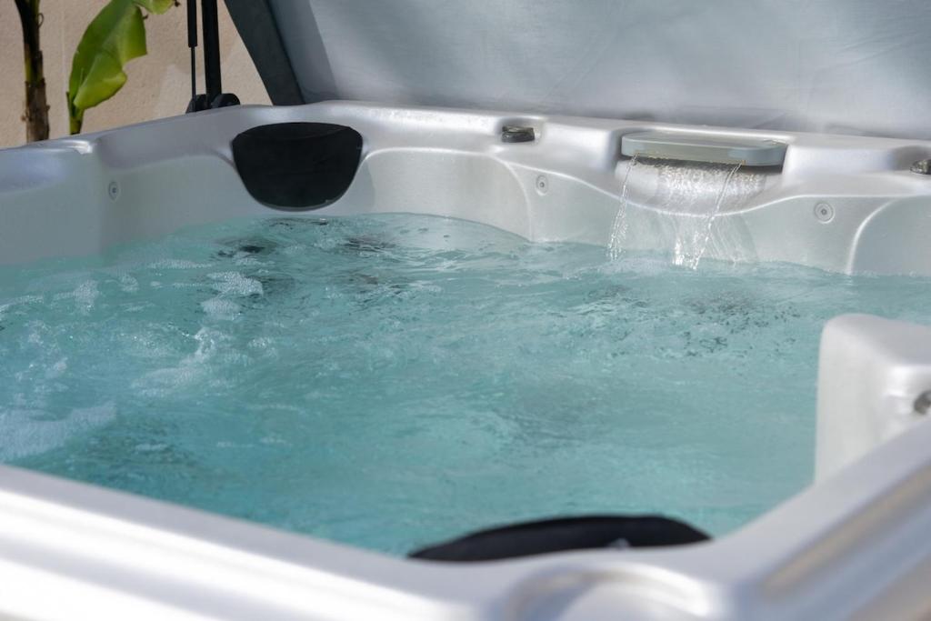 a bath tub filled with blue water with a fountain at L'air de Riez in Saint-Hilaire-de-Riez