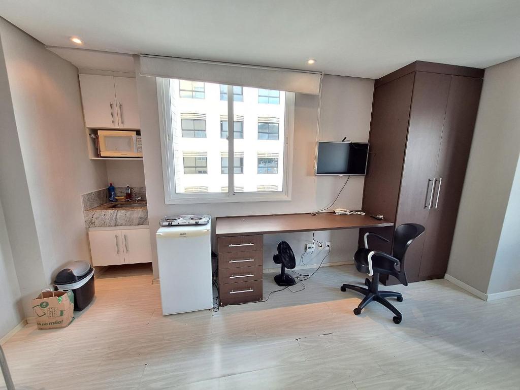 una cucina con scrivania, frigorifero e finestra di LK Estoril 3 a Belo Horizonte