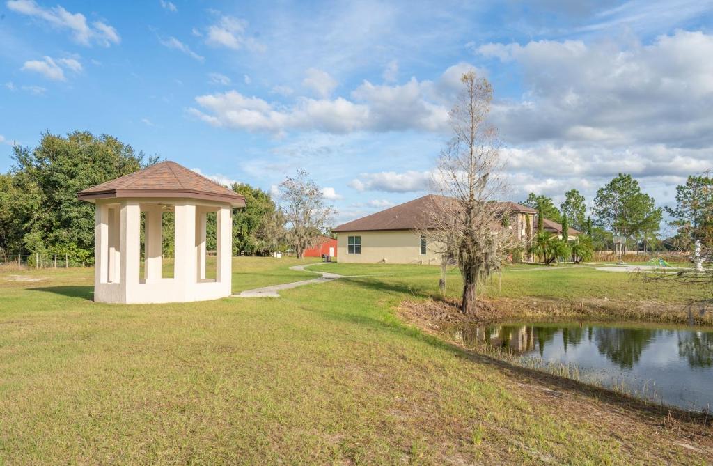a gazebo in a yard next to a pond at Pondfront Ranch • Theater Room • Sleeps 8 in Eagle Lake