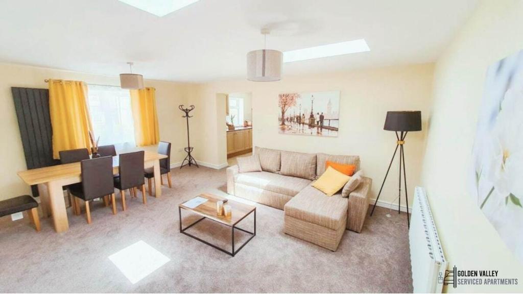 un soggiorno con un divano e un tavolo di White Jasmine in Stroud a Dudbridge