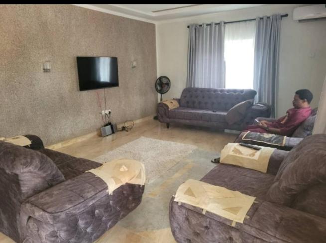 a man sitting on a couch in a living room at KOOZE Integrated Services Ltd 