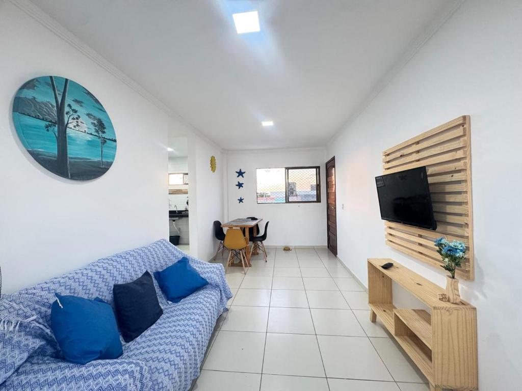 a living room with a couch and a flat screen tv at Apê aconchegante perto do mar in Cabedelo