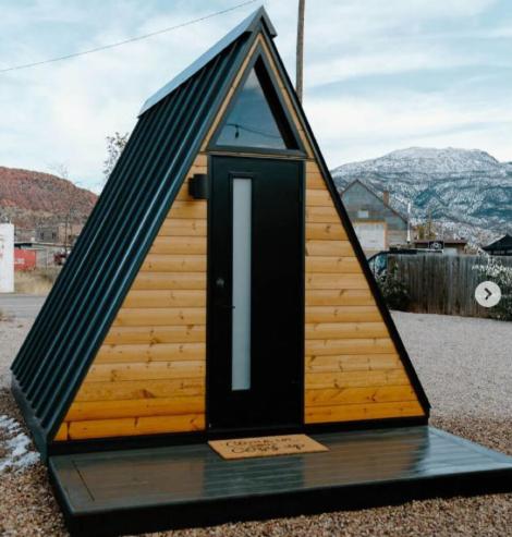 Água BoaChalé Madeira 1的桌子上放着一栋黑色门的小屋。