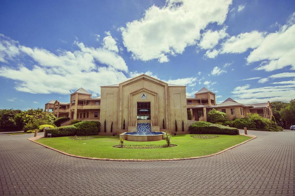 a building with a fountain in the middle of a courtyard at Abbey Beach Resort in Busselton