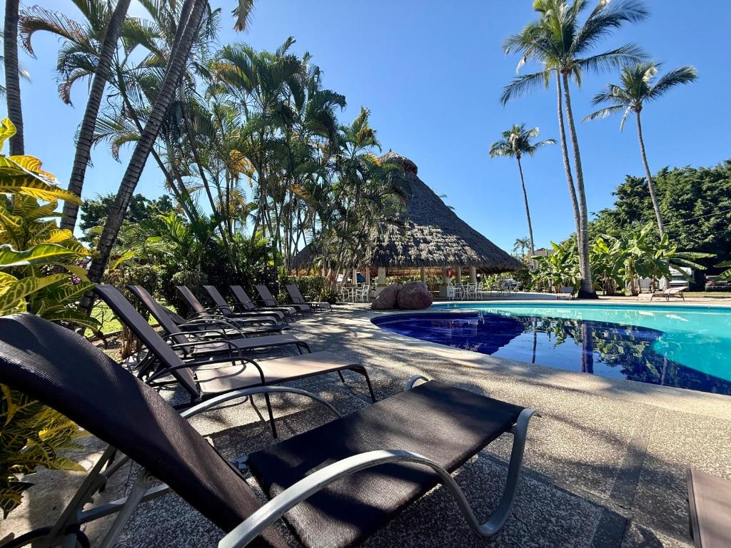 een groep stoelen naast een zwembad bij Premium Glamping - Pool Waterslide Wi-Fi & Private Patio Lounge in Puerto Vallarta
