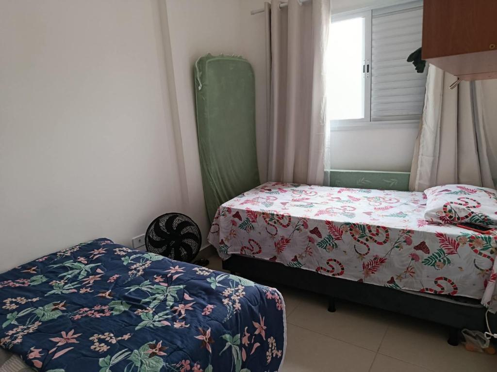 ein Schlafzimmer mit zwei Betten und einem Fenster in der Unterkunft Casa temporada Itanhaém in Itanhaém