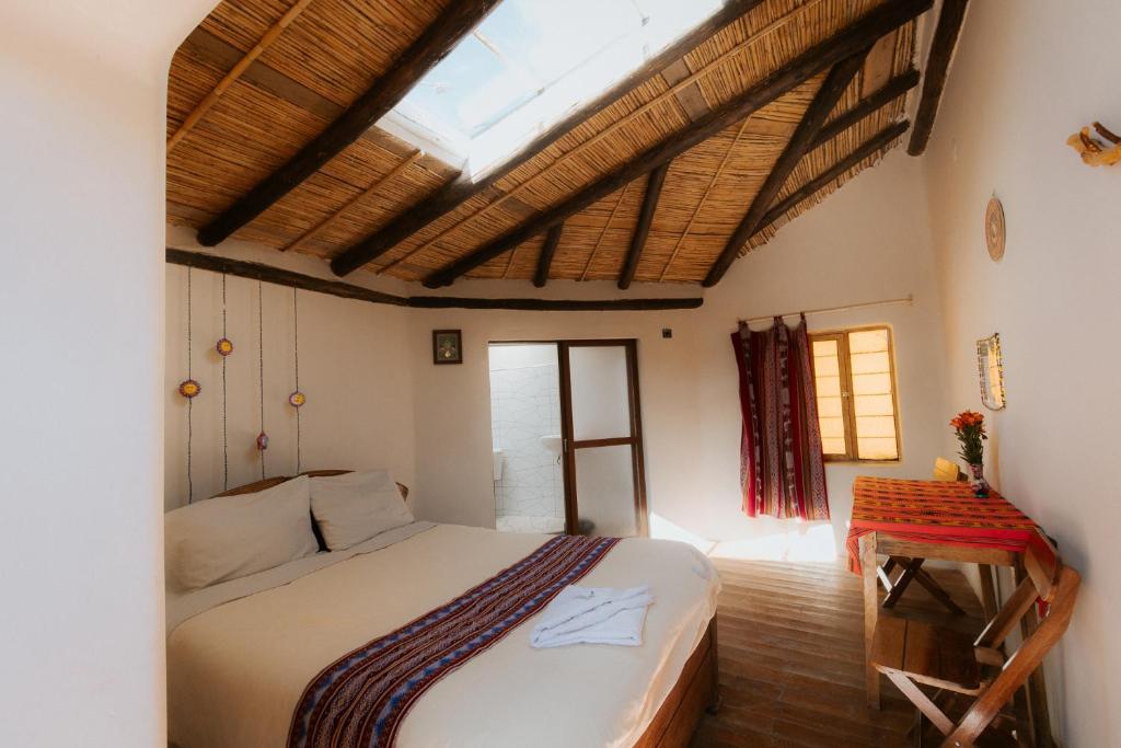 a bedroom with a large bed and a skylight at Sonidos del Ande Wasi in Pisac