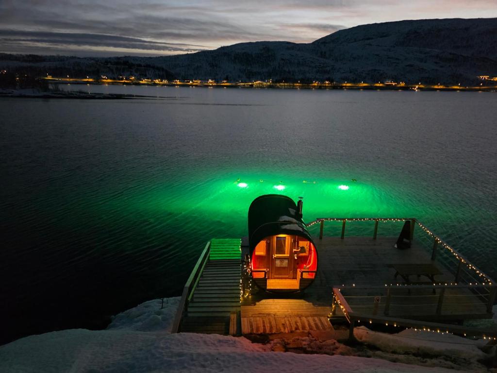 een klein bootje op het water 's nachts bij Kaldfjord Sea House in Tromsø