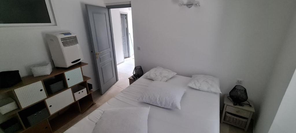 ein Schlafzimmer mit einem weißen Bett und einem Fernseher in der Unterkunft Zilia in Zilia