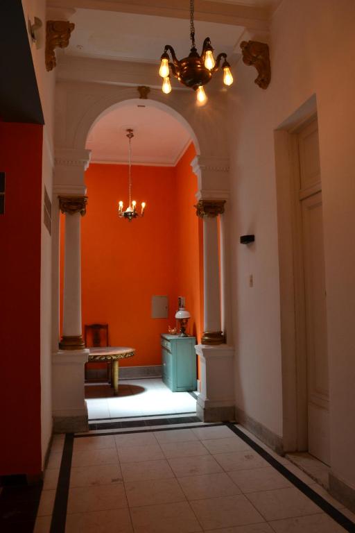 an empty hallway with an orange wall and a table at Pin-up hostel in Rosario