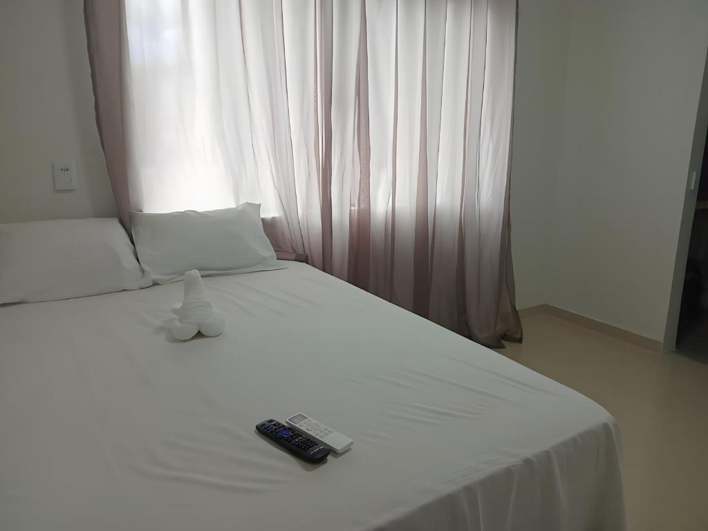 ein weißes Bett mit zwei Fernbedienung in der Unterkunft Lençóis Barreirinhas in Barreirinhas