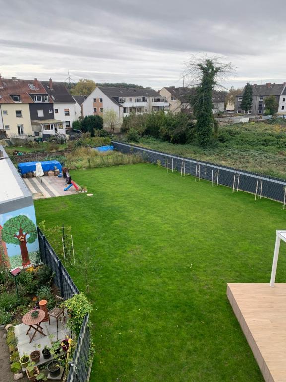 a large yard of green grass with houses in the background at Schickes Apartment in Herten