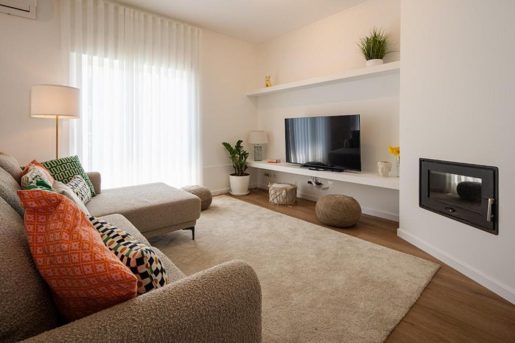 a living room with a couch and a tv at Bright & Spacious Villa by Beach in Ribeira Grande