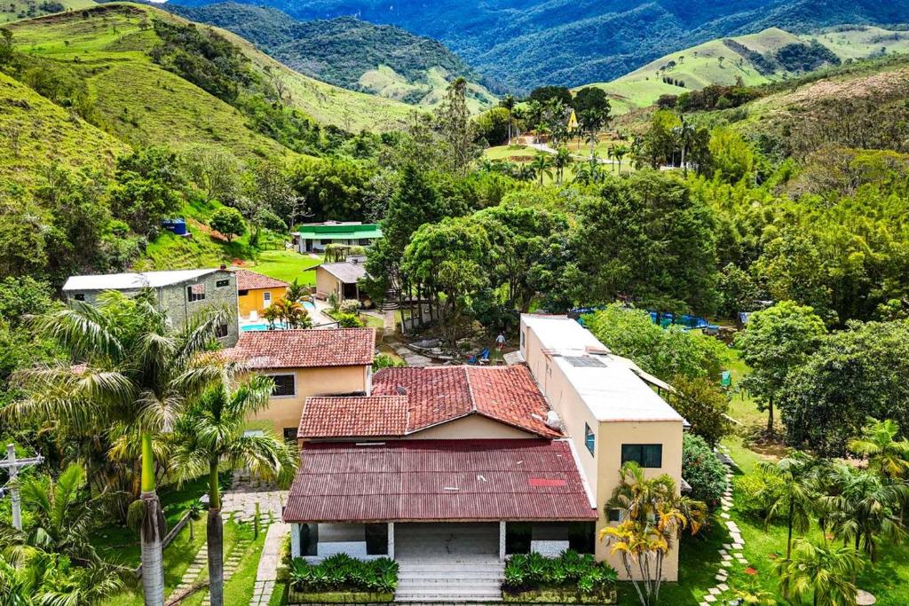 a village in the mountains with palm trees and houses at Recanto Bamboo in Lavrinhas