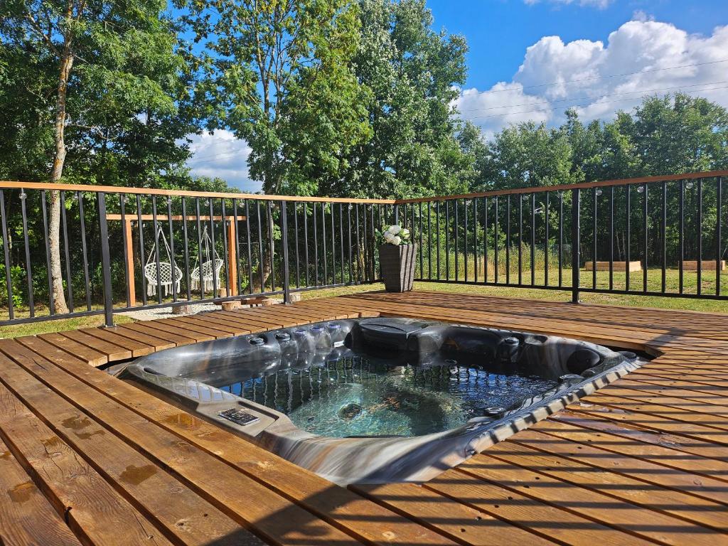 a hot tub on a deck with a fence at Tomina Koliba Lika in Sveti Rok
