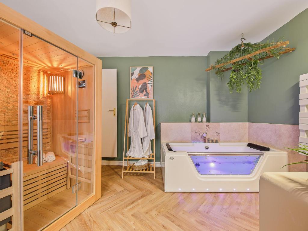 bagno con ampia vasca e doccia di L'Evasion Tropicale - idéal couple - sauna - baignoire balnéo LED - TV 4K Ambilight 130cm - parking gratuit à 2 pas du logement - wifi - maison médiévale sur 2 étages - entièrement rénovée 37m2 a Bargemon