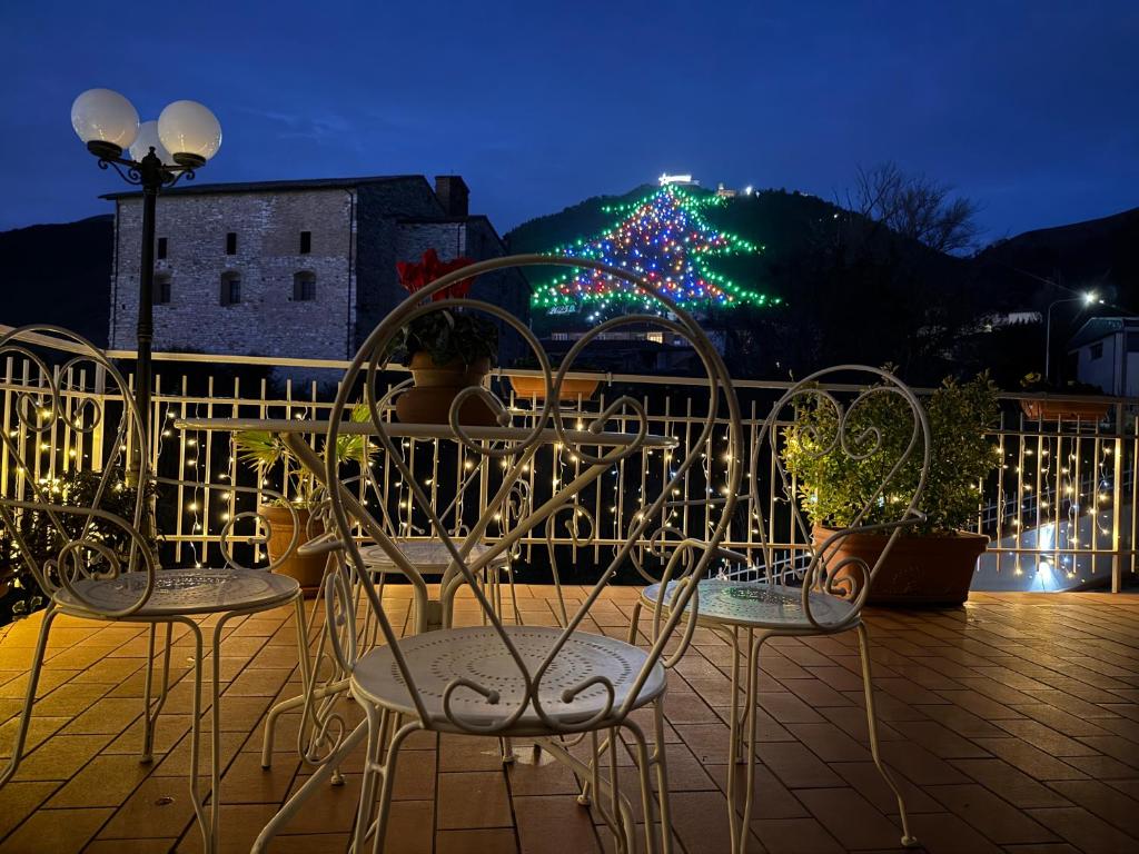 een groep stoelen en een kerstboom met lampjes bij Casa Stefy Gubbio in Gubbio