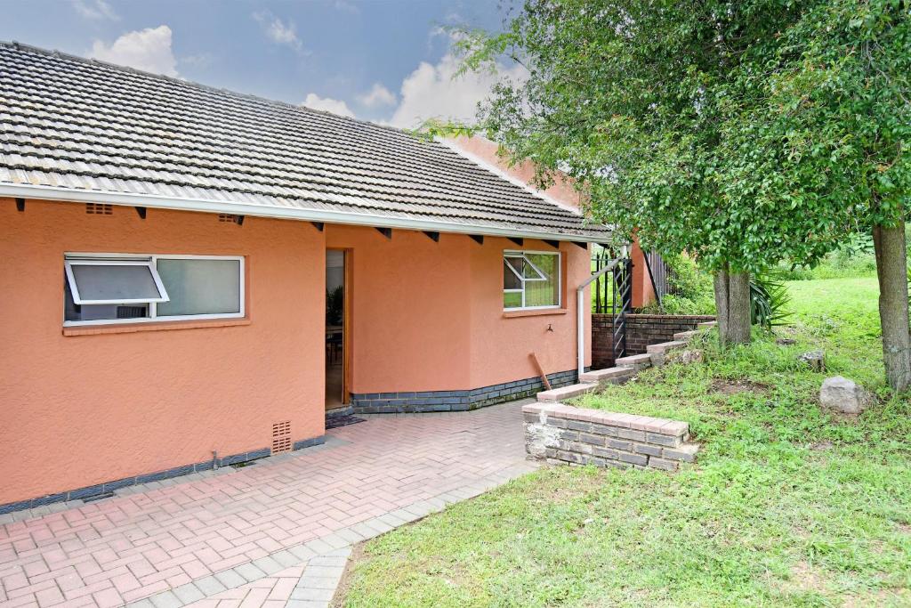 een oranje huis met een bakstenen pad ervoor. bij Sandton Elite Stay in Sandton
