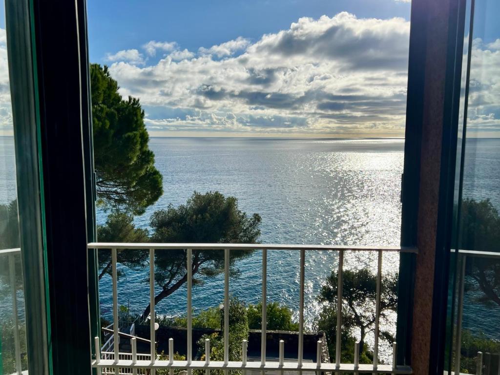 a view of the ocean from a window at Mimosa Seafront Apartment - Free parking Wi-Fi in Varazze
