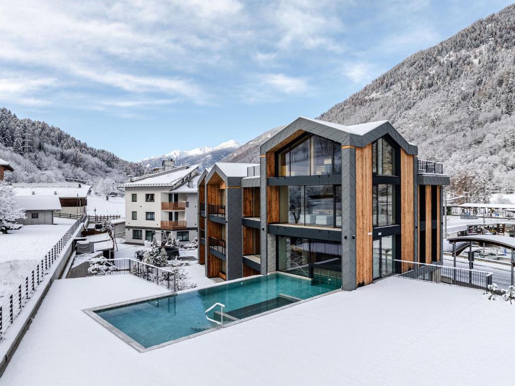 a house in the snow with a swimming pool at Monroc Hotel in Commezzadura