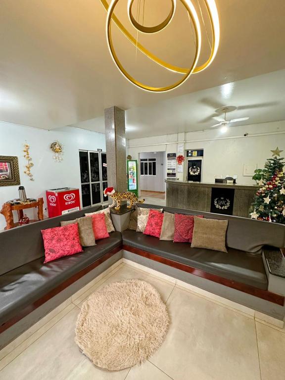 a living room with a long couch with red pillows at Hotel Monte Carlo - Cáceres in Cáceres