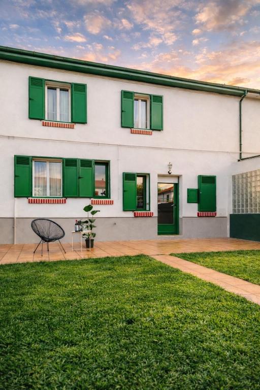 a white building with green shutters on it at Casa Verde Logroño in Logroño