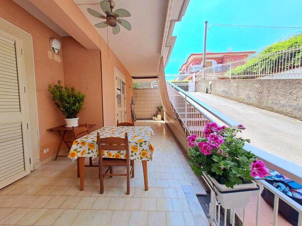 een tafel en stoelen op een balkon met bloemen bij Ambra in Stazzo