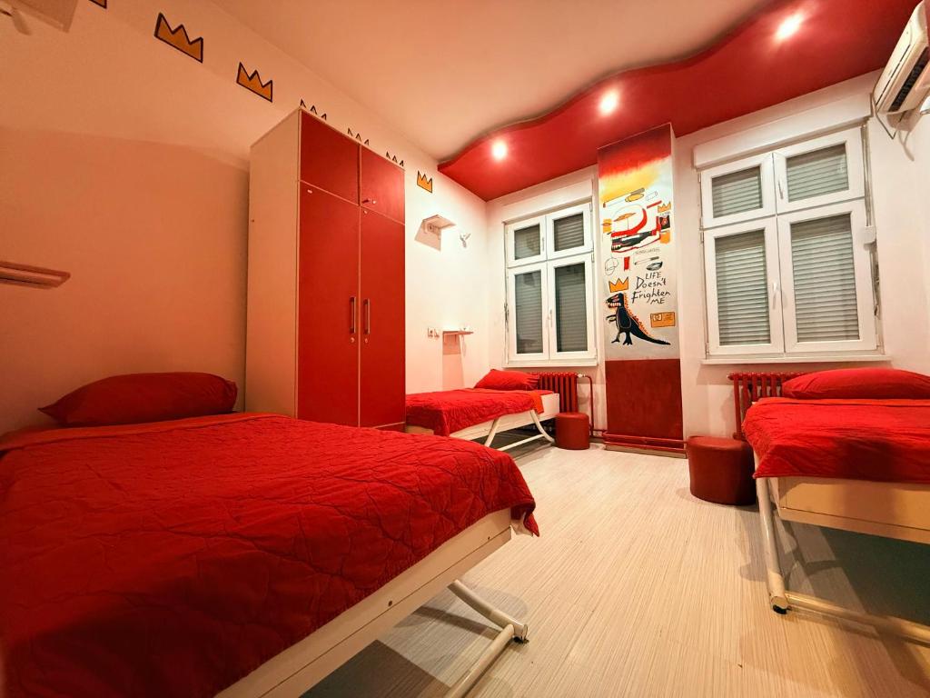 een slaapkamer met twee bedden en rode lakens bij Pop Art in Belgrado