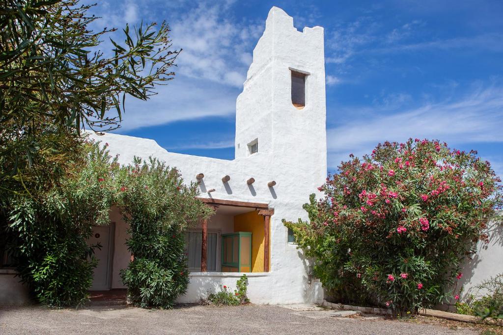 una casa bianca con dei fiori sul lato di Desert Tracks Rancho a Las Grutas
