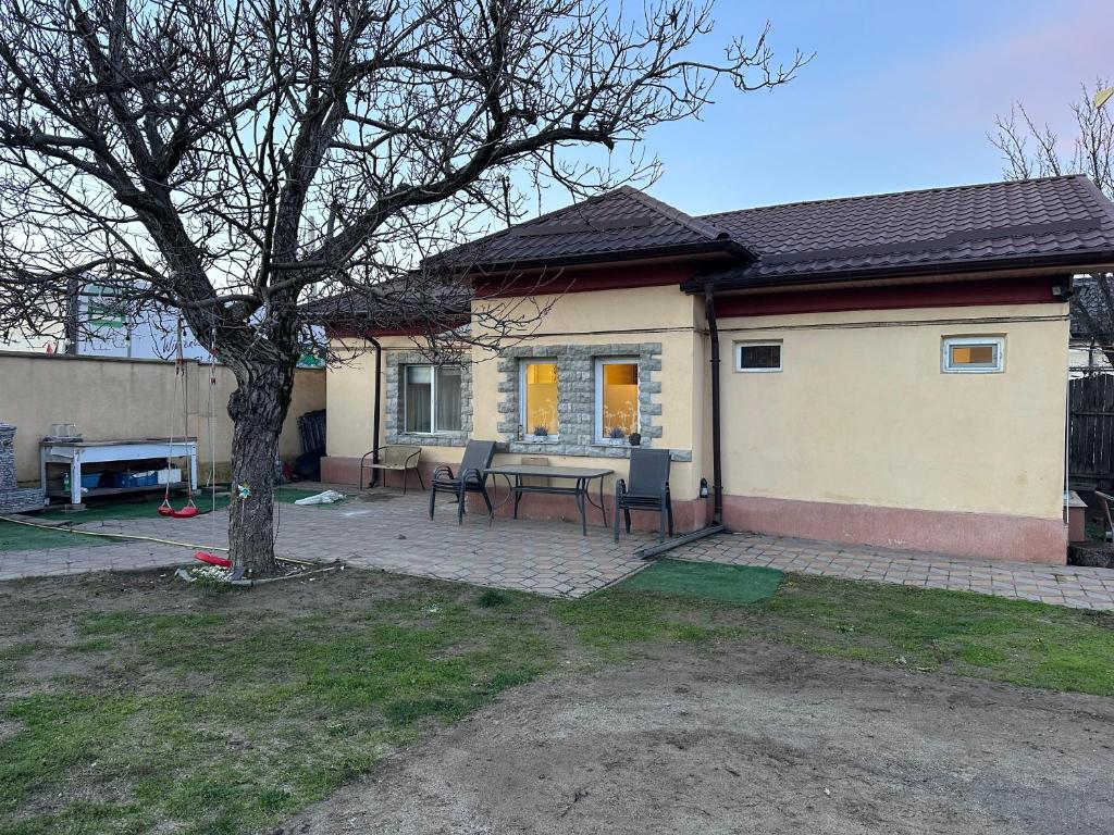 una casa con un tavolo e un albero nel cortile di Căsuța Tenu a Craiova