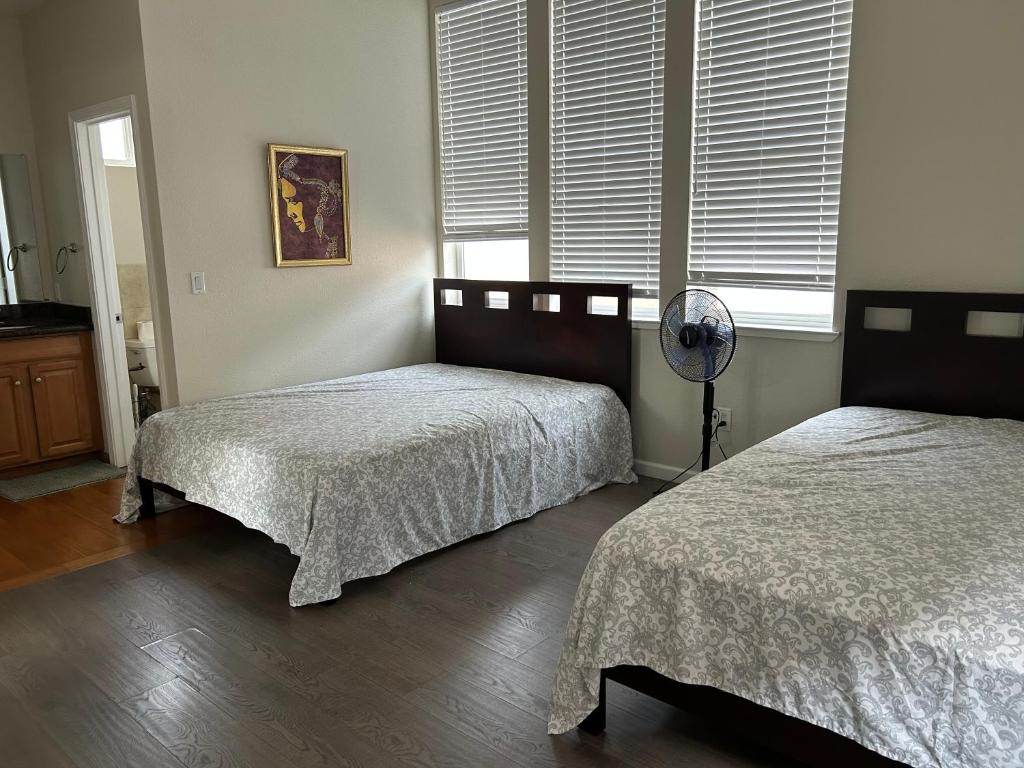 una camera con 2 letti e un ventilatore di Tranquility home a Hayward