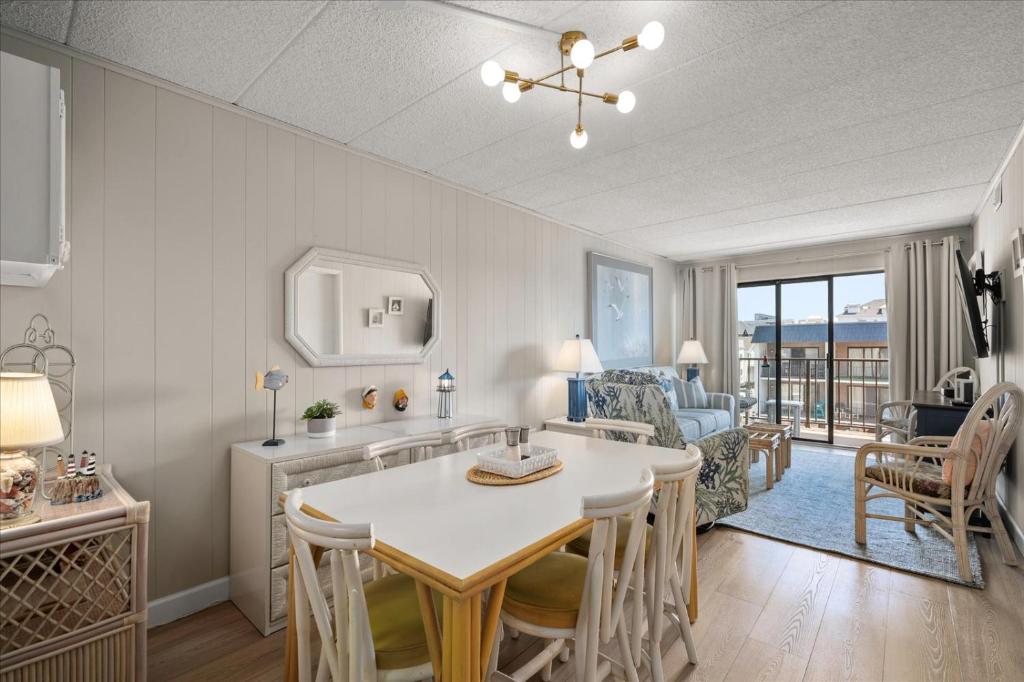 a kitchen and living room with a table and chairs at 2 Bedroom Ocean Block Condo, Steps to the Beach! in Ocean City